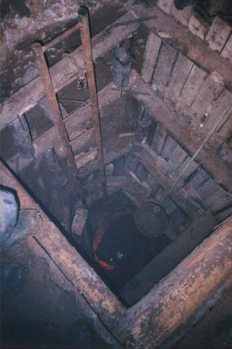 Pohled est a pl metru hlubokou vydevenou studnou na dno na Benyho, jen intenzivn pracuje s kladivem (a kameny).