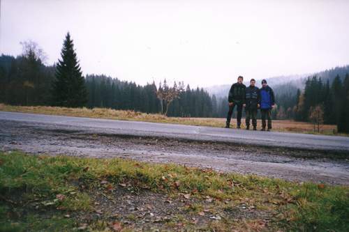 (Zleva) Kvtko, Skrblk a Maran stoj na silnici na Modrav. Daleko za nimi se v mracch ztrc bo Modravsk hory.